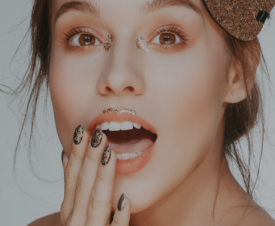 a woman with glittery makeup and manicure